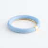 Bracciale rigido in resina con dettagli in metallo a contrasto