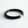 Bracciale rigido in resina con dettagli in metallo a contrasto